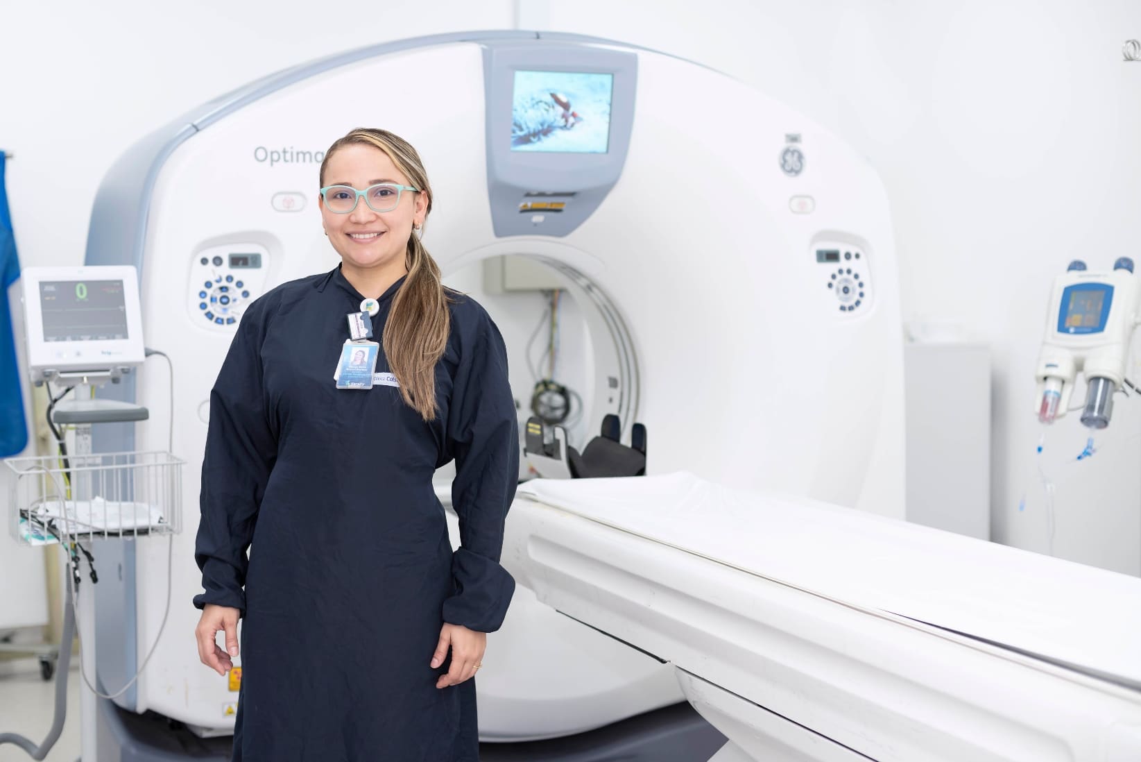 Especialista parada al lado izquierdo de máquina de pruebas médicas. 